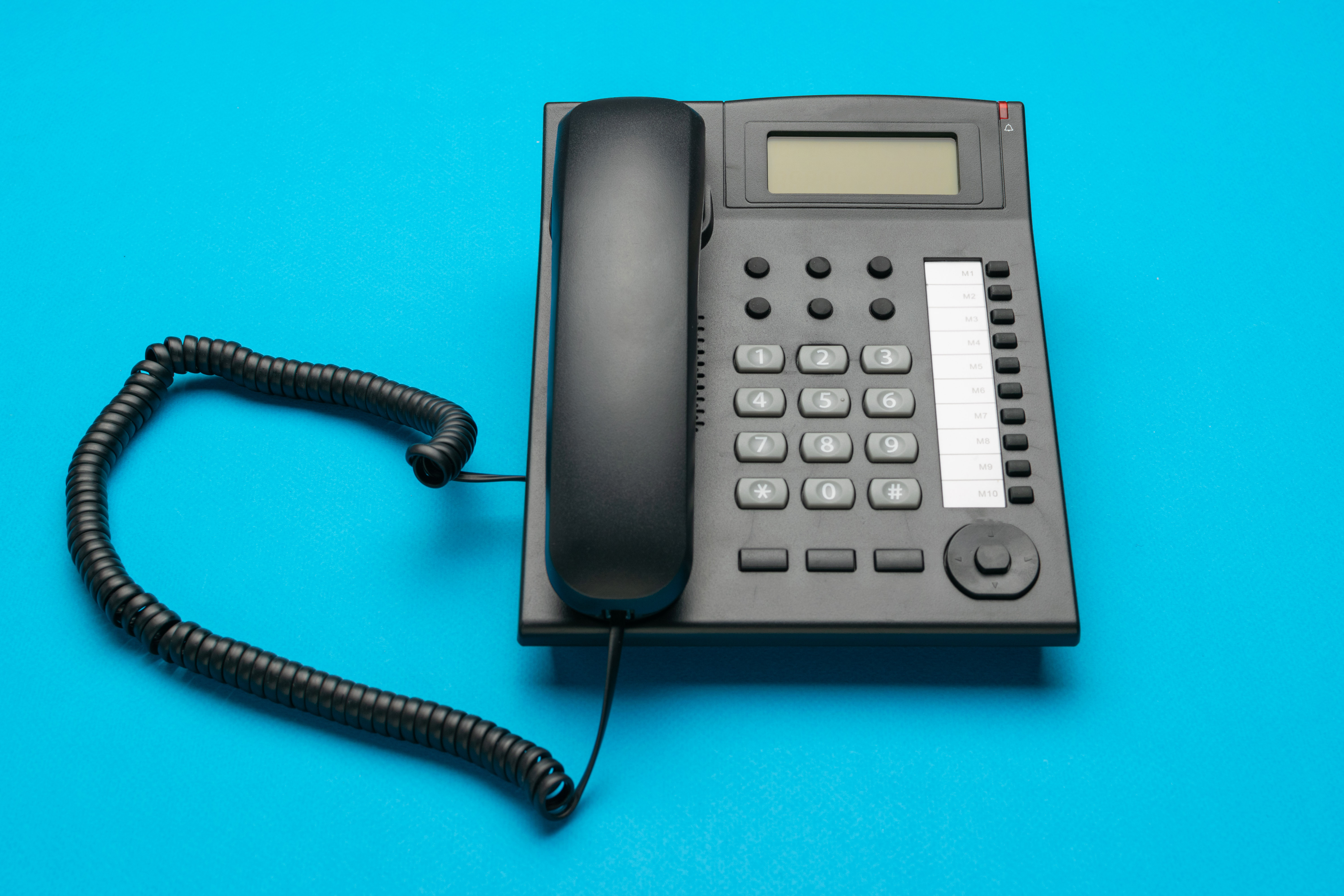 Black Office Telephone on Bright Blue Background Showcasing Modern Business Communication